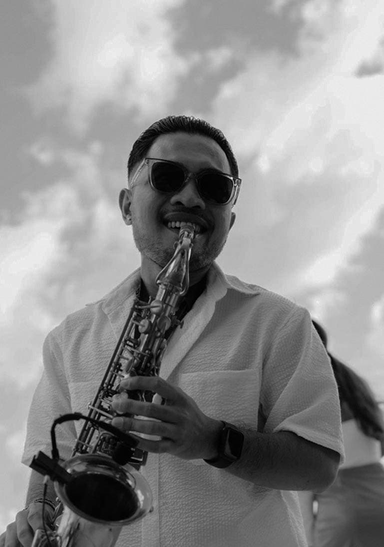 Musician playing saxophone on day party at Finns